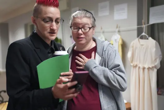  ?? Photos by Jessie Wardarski, The Associated Press ?? Sexual assault survivors Mary Byler, left, born Amish, and Hope Anne Dueck, whose background is Mennonite, look at a video taken of their exhibit, which displays articles of clothing from sexual assault survivors, on April 29 in Leola, Pa.