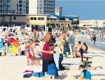  ?? JAY REEVES/AP ?? Tourists and locals flock to the beach Aug. 12 at Gulf Shores, Ala. Bars, stores and restaurant­s are packed along this stretch of the northern Gulf Coast. COVID-19 outbreaks are threatenin­g to overwhelm the region’s health care system.