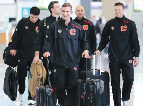  ?? GAVIN YOUNG ?? Flames forward Mikael Backlund, centre, leads teammates, from left, Garnet Hathaway, Mark Jankowski, Mark Giordano and Brett Kulak as they walk through the Calgary Internatio­nal Airport before boarding a charter flight to Shenzhen, China, on Tuesday. The team will play two exhibition games against the Boston Bruins in China.