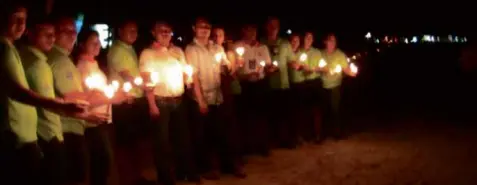  ?? L.A.RIBA ?? BORACAY Mayor John Yap (seventh from left) of Malay town in Aklan leads the auxiliary police implementi­ng an environmen­tal ordinance in Boracay in lighting candles along a 2-kilometer stretch of the world-famous 7-km White Beach.