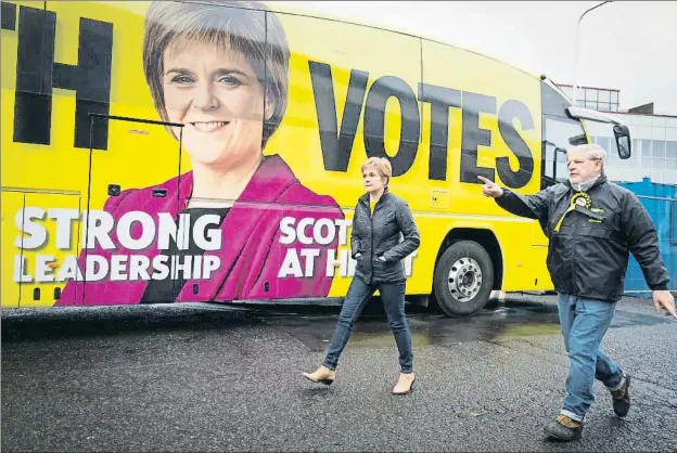  ?? POOL / REUTERS ?? La primera ministra escocesa, Nicola Sturgeon, y Angus Robertson, candidato del SNP por Edimburgo, ayer de campaña electoral en Gorgie