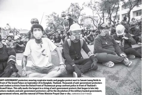  ?? Lauren Decicca /Getty Imag es ?? Anti- government protesters wearing respirator masks and goggles protest next to Sanam Luang fields in front of The Grand Palace on September 20 in Bangkok, Thailand. Thousands of anti-government protestors and student activists from the United Front of Thammasat group confront police in front of Thailand’s Grand Palace. This rally marks the largest in a string of anti-government protests that began in late July where students and anti-government protesters call for the dissolutio­n of the military backed government, government reform, and the removal of Prime Minister Prayut Chan-o-cha.