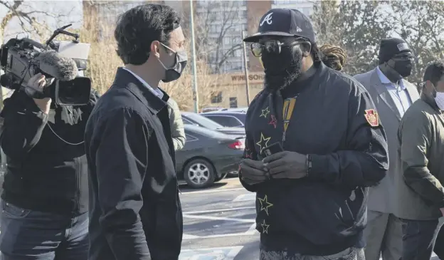  ??  ?? 0 Democratic Senate candidate Jon Ossoff speaks with a voter in Atlanta, Georgia, as polls opened for the two key senate run-off elections