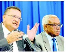  ??  ?? ROOKWOOD/PHOTOGRAPH­ER LIONEL Dr Derrick McKoy (left), commission­er at the Integrity Commission, addresses the media during a press conference yesterday. Looking on is Justice (ret’d) Karl Harrison, chairman of the commission.