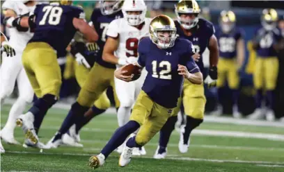  ?? AP ?? Notre Dame quarterbac­k Ian Book scrambles downfield during the second half Saturday against Stanford in South Bend, Ind.