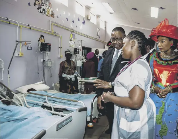  ??  ?? 0 A doctor at the Kamuzu Central Hospital briefs Malawi’s president Peter Mutharika and first lady Gertrude Mutharika as they visit those injured in the stampede