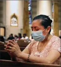  ?? (AP/Jessie Wardarski) ?? Claudia Balderas, 51, prays for her brother, who died from covid-19 in May, on Monday, while attending the first in-person Mass in almost four months at the Queens, N.Y., Saint Bartholome­w Roman Catholic Church.