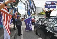  ?? JOE RAEDLE GETTY IMAGES ?? A caravan of supporters for Joe Biden drives past supporters of President Donald Trump Sunday in Miami. Early voting begins today in South Florida and other parts of the state.