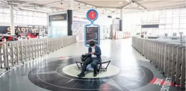  ?? Agence France-presse ?? ↑
A man looks at his mobile phone in a closed Toyota showroom in Tokyo on Wednesday.