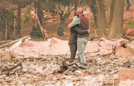  ?? Josh Edelson / AFP/Getty Images ?? Chris and Nancy Brown embrace as they look over what remains of their burned residence after the Camp Fire tore through the region in Paradise, Calif.