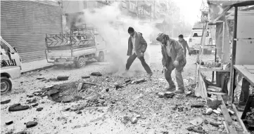  ??  ?? Syrians check the damage following Syrian government shelling on the town of Douma in the rebel-held enclave of Eastern Ghouta on the eastern outskirts of the capital Damascus. — AFP photo