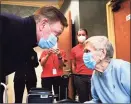  ?? Stephen Dunn / Associated Press ?? Gov. Ned Lamont greets Jeanne Peters, 95, a rehab patient at The Reservoir, a nursing facility, after she was given the first COVID-19 vaccinatio­n at the nursing home Friday in West Hartford.