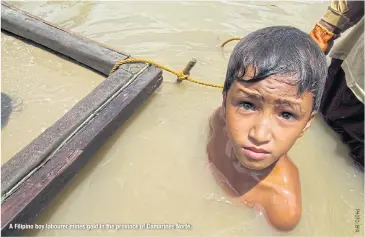  ??  ?? A Filipino boy labourer mines gold in the province of Camarines Norte.