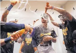  ?? JEFF ROBERSON/ASSOCIATED PRESS ?? Milwaukee’s Keon Broxton, center, is doused as he celebrates with teammates after the Brewers beat St. Louis to clinch at least a wild-card berth in the NL.