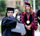  ?? Staff file photo ?? Bernice De Luna flips her tassel near Texas A&M University­san Antonio President Cynthia Tenientema­tson during a curbside commenceme­nt last May.