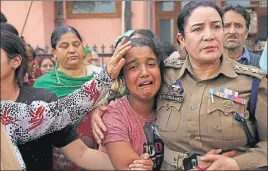  ??  ?? A J&K Police officer consoles the daughter of policeman Deepak Thusoo during his funeral in Jammu on Thursday.