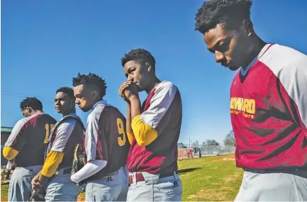  ?? STAFF PHOTO BY DOUG STRICKLAND ?? The Howard high school baseball team lines up for Its first home baseball game in seven years Wednesday. The community rallied to donate materials, and the team and volunteers worked to restore the field for the school’s baseball program.