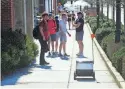  ?? JAMAR COACH/NEWS SENTINEL ?? University of Tennessee students watch as a Starship delivery robot approaches them on Volunteer Boulevard.