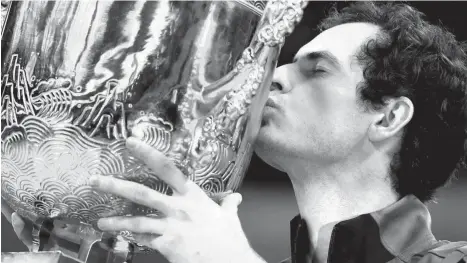 ?? AP Photo/Andy Wong ?? KISS OF VICTORY. Andy Murray of Britain kisses his winner's trophy after defeating Gregor Dimitrov of Bulgaria in the men's singles final match at the China Open tennis tournament in Beijing, Sunday, Oct. 9, 2016.