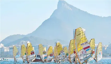  ??  ?? Competidor­es en tablas de vela se dirigen a la salida de la regata de antier en la Bahía de Guanabara, en parte de la acción en la Regata Internacio­nal Aquece Rio, que sirve de ensayo a las venideras olimpiadas.