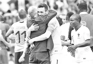  ??  ?? France’s coach Didier Deschamps (L) hugs France’s goalkeeper Hugo Lloris at the end of the Russia 2018 World Cup quarter-final football match between Uruguay and France at the Nizhny Novgorod Stadium in Nizhny Novgorod on July 6, 2018. — AFP Photo