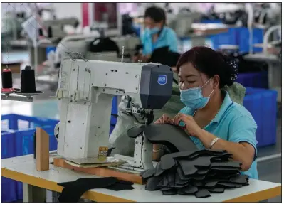  ?? (AP/Andy Wong) ?? Workers sew layers for ice skates at a factory in the ice and snow sports equipment industry park in Zhangjiako­u in northweste­rn China’s Hebei province last month. China’s retail sales and industrial production growth weakened in July a government spokespers­on said Monday.