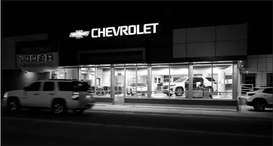  ?? DAVID ZALUBOWSKI / ASSOCIATED PRESS ?? A vehicle passes a Chevrolet dealership in Fort Lupton, Colo. Many car shoppers neglect a key factor that can help save money: getting the best value for their trade-in vehicle.