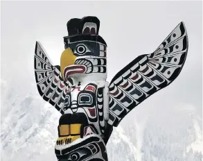  ?? JENELLE SCHNEIDER/VANCOUVER SUN FILES ?? This totem pole in Stanley Park makes a striking image set against the mountains. There is a movement against the commercial­ization of the Indigenous carving.