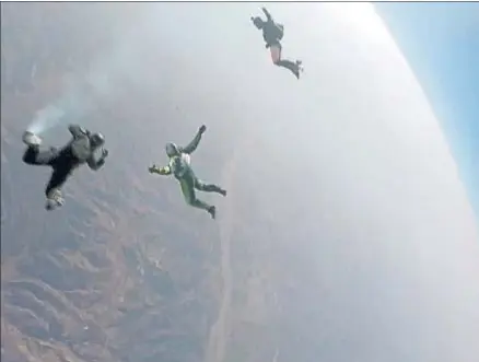  ?? AP ?? Momento del salto de Luke Aikins, en el centro, acompañado de dos paracaidis­tas, que grabaron la proeza.
