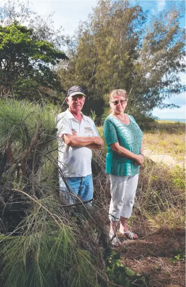  ?? Picture: BRENDAN RADKE ?? NEGLECTED: Lido Deauville apartment owners Dave Spowart and Gaye Benck stand beside casuarina trees on the beachfront that were pruned some time ago.