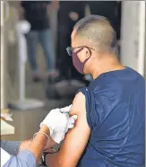  ?? SUNIL GHOSH /HT PHOTO ?? A health worker administer­s the Covid-19 vaccine to a man at a hospital in Noida on Friday.