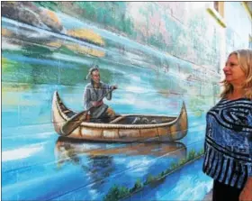  ??  ?? Our Town Foundation Executive Director Deena Kershner admires the mural at Hamburg State Street Square.