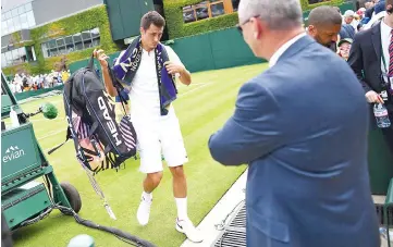  ?? — AFP photo ?? Australia’s Bernard Tomic leaves the court after losing against Germany’s Mischa Zverev during their men’s singles first round match on the second day of the 2017 Wimbledon Championsh­ips at The All England Lawn Tennis Club in Wimbledon, southwest London, on July 4, 2017.