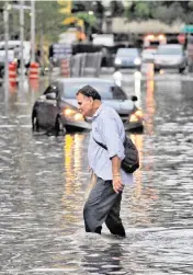  ?? CARL JUSTE cjuste@miamiheral­d.com ?? Pedestrian­s make their way through the flooded streets of Brickell on Aug. 1, 2017.