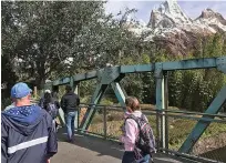  ?? Gabrielle Russon/Orlando Sentinel/TNS ?? ■ Expedition Everest looks beautiful, the sun shining down like a beacon, as Shane Lindsay, left, and Kristina Hawkins, right, walk past. Unfortunat­ely, the Animal Kingdom ride was their nemesis. Cold temperatur­es meant the ride opening was delayed.