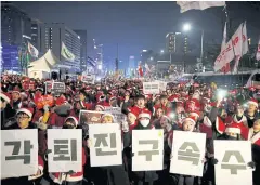  ?? REUTERS ?? People dressed in Santa costumes attend a protest in Seoul on Friday demanding South Korean President Park Geun-hye’s resignatio­n.