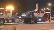  ?? JAMES B. NELSON / MILWAUKEE JOURNAL SENTINEL ?? A Milwaukee police squad car that was involved in a rollover crash is prepared to be towed away from the scene Thursday night. One officer was killed and another injured in the crash.