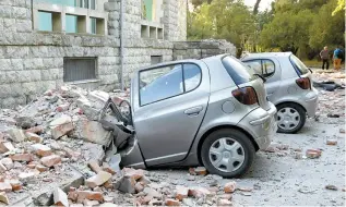  ?? Reuters-Yonhap ?? Destroyed cars stand next to a damaged building after an earthquake in Tirana, Albania, Saturday. Albania was rattled by its strongest earthquake in decades Saturday, officials said, sending people fleeing into the streets in several cities, damaging buildings and triggering power cuts in the capital.