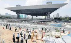  ??  ?? CONSTRUCTI­ON DELAYS: Journalist­s tour the Aquatics Centre under constructi­on in Tokyo. Oganisers say delays will have no impact on preparatio­ns for the games.