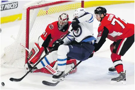  ?? PATRICK DOYLE/CANADIAN PRESS ?? Ottawa’s Thomas Chabot upends the Jets’ Patrik Laine as he tries to score on Craig Anderson Monday night.