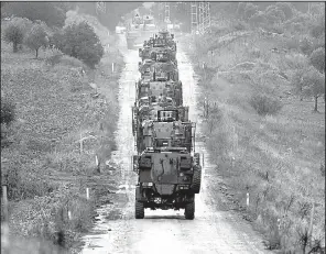  ?? AP/IBRAHIM MASE ?? A column of Turkish armored vehicles moves toward the Syrian border Tuesday to battle U.S.-backed Kurdish militias. U.S. and French officials on Tuesday urged Turkey to use restraint in the offensive.