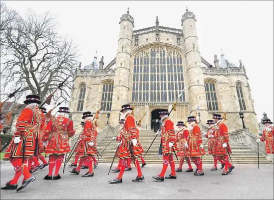  ?? Chris Jackson Getty Images ?? YEOMEN of the Guard walk past St. George’s Chapel in Windsor, England, on March 29. The chapel where Prince Harry and Meghan Markle will wed dates to 1483.