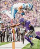  ?? Jerry Holt / Associated Press ?? Detroit wide receiver Amon-Ra St. Brown leaps over Minnesota cornerback Patrick Peterson while picking up a first down at the 2-yard line in Vikings' 28-24 win on Sunday.