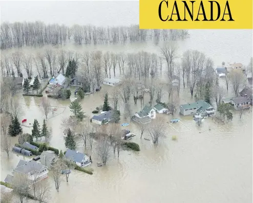  ?? PAUL CHIASSON / THE CANADIAN PRESS ?? Water spills over to homes in Rigaud, Que., on Monday in what the provincial government is calling historic flooding.