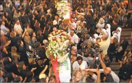 ?? Khalid Mohammed Associated Press ?? MOURNERS carry the caskets of victims of a 2010 church massacre in Baghdad. The attack by Islamic militants deepened Christian mistrust toward Muslims.