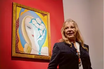  ?? Alberto Pezzali/associated Press ?? Pattie Boyd stands next to a painting used for a 1970 Derek and the Dominoes album cover, part of a collection for sale at Christie’s auction house in London.