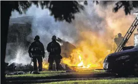  ?? THE PRESS-ENTERPRISE ?? Firefighte­rs are on the scene of a plane crash in Riverside, Calif., on Monday. The deadly crash injured several when a small plane wrecked into two homes.