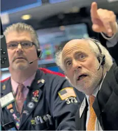  ?? BRYAN R. SMITH/GETTY IMAGES ?? Traders work on the floor at the closing bell of the Dow Industrial Average at the New York Stock Exchange.