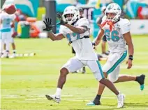  ?? AMY BETH BENNETT/ SOUTH FLORIDA SUN SENTINEL ?? Dolphins wide receiver Jaylen Waddle catches a pass ahead of fellow wide receiver Mack Hollins during training camp on Aug. 4.