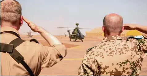  ?? Archivfoto: Marc Tessensohn, dpa ?? Zwei Bundeswehr­soldaten salutieren während der Ankunft der ersten zwei Kampfhubsc­hrauber des Typs Tiger in Mali im März. Der Helikopter wird im Donauwörth­er Air bus Werk gebaut.